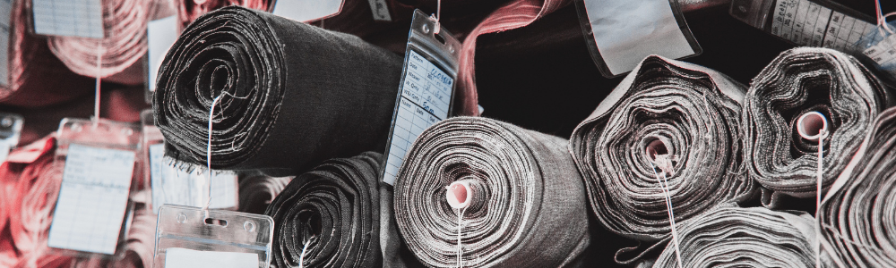 James Heal - Rolls of fabric stacked up