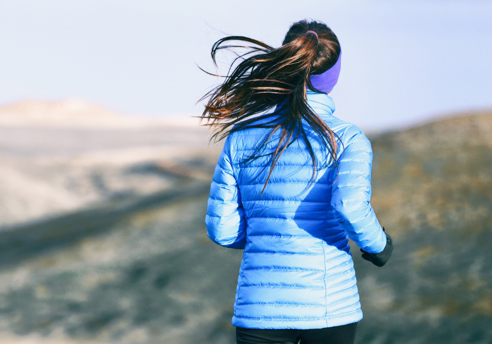 Women in Down Puffer Jacket runs through hills