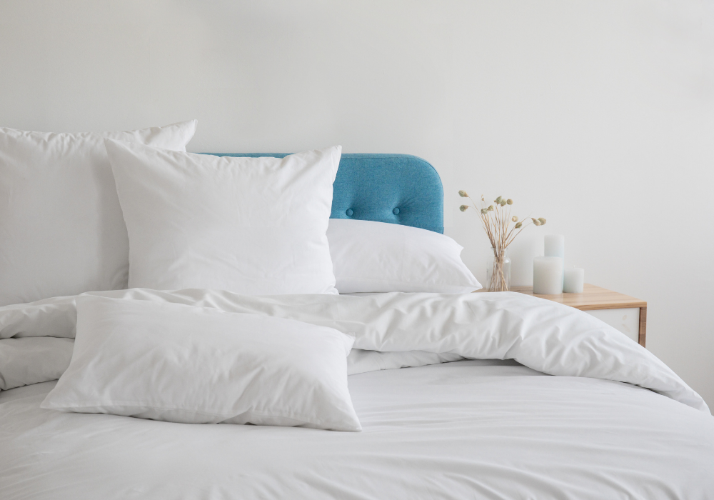 white bedding with a blue headboard and pillows