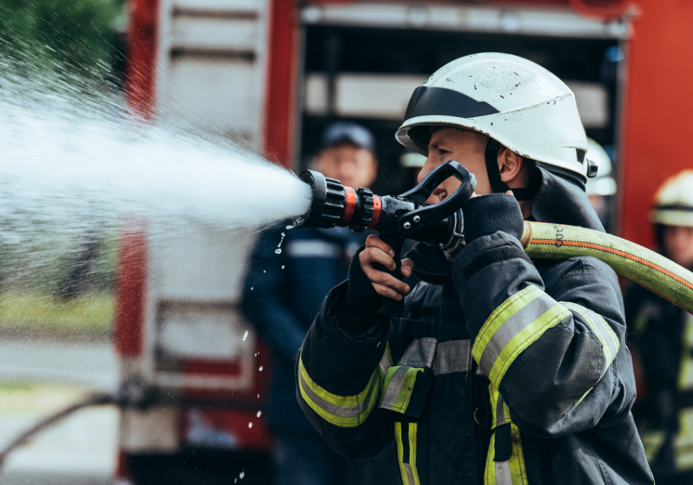 fire fighter using a hose to spray water