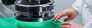 Test operator positioning test specimen on air permeability test bed