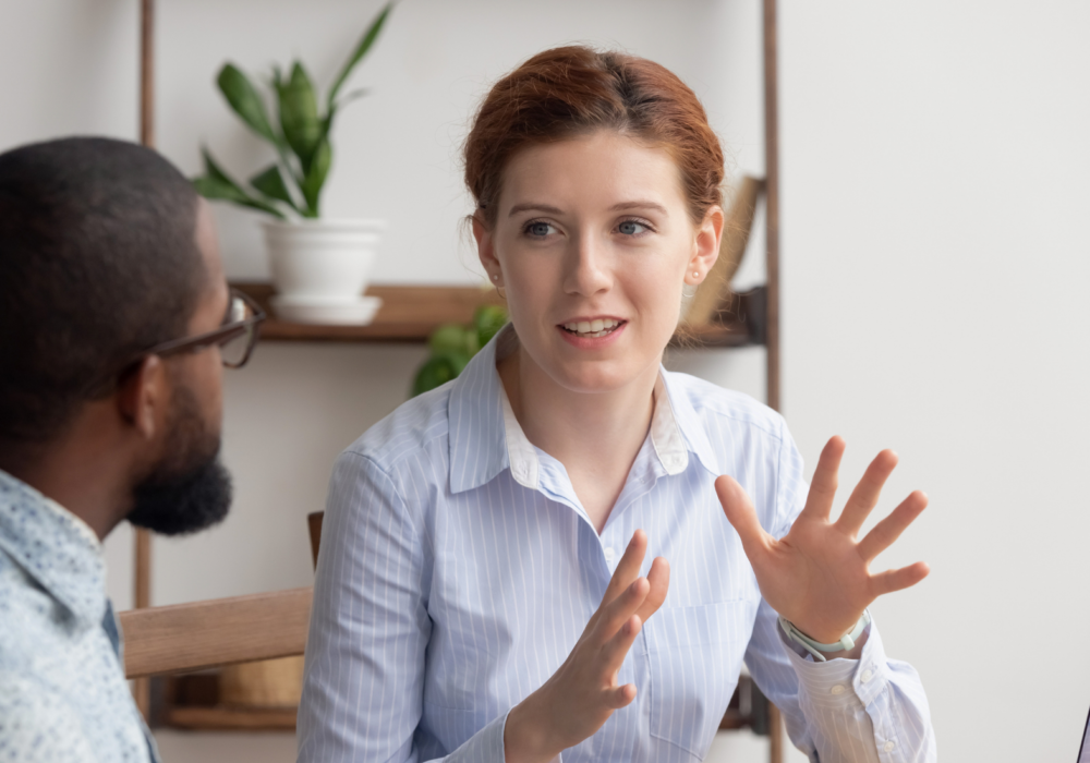 Two people sat at desk in workplace