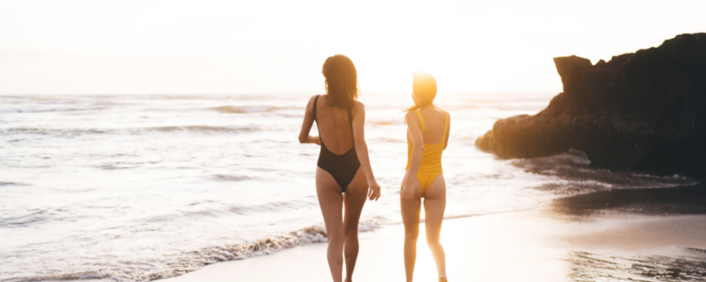 Two women in swimwear on a sunny beach
